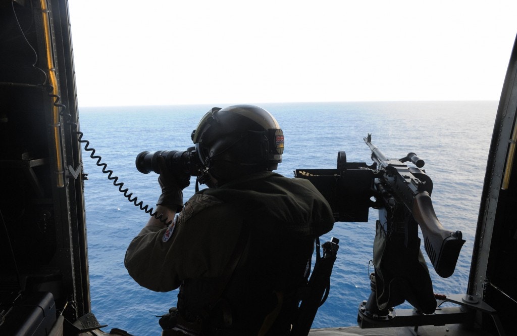 A Canadian Navy sailor on board a helicopter patrols the waters off the coast of Somalia as they escort a World Food Program ship on Sept. 17, 2008, providing an anti-pirate escort for the ship taking food aid to Somalia. Photo: Simon Maina/AFP/Getty